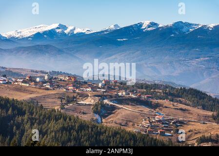 Bulgarischen Dorf Smolevo in Rhodopen vor schneebedeckten Gipfeln Rila Stockfoto