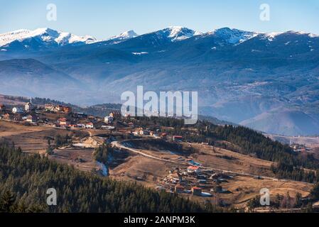 Bulgarischen Dorf Smolevo in Rhodopen vor schneebedeckten Gipfeln Rila Stockfoto