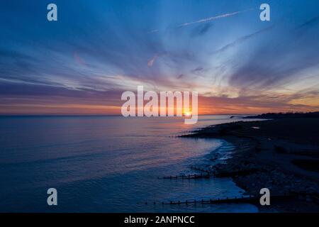 Wunderschöner und Dramatischer Blick auf den Sonnenuntergang entlang des Climping Beach mit Lichtreflexionen im Meer. Stockfoto