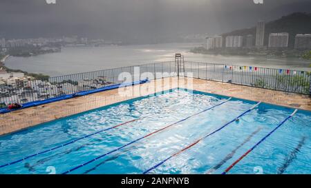 Leeren Pool mit Blick auf die Lagoa Rodrigo de Freitas in Rio de Janeiro, Brasilien. Von Cantagalo favela Gefangen Stockfoto