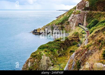Zug Verlassen eines Tunnels. Blick von der Klippe entfernt Bray Greystones mit wunderschönen Küste, Felsen und Meer, Irland Stockfoto