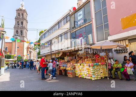 Celaya, Guanajuato, Mexiko - 24. November 2019: Touristen und Einheimische einkaufen bei Street Market entlang Gongora St. mit der Unbefleckten Empfängnis Cathedr Stockfoto