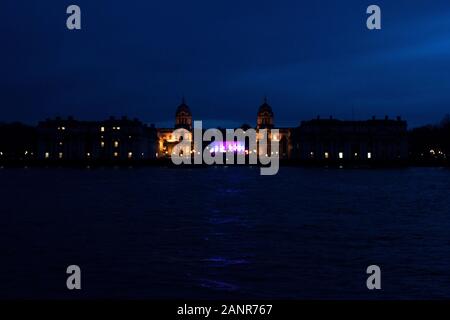 Royal Naval College in Greenwich, fotografiert in der Nacht von Insel Gärten, über die Themse. Das Queen's House leuchtet mit Rosa und Lila. London, E Stockfoto