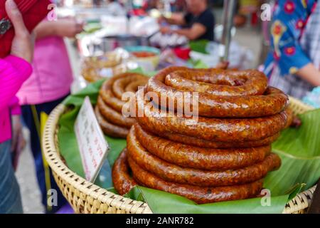 Ein Stapel Spiralwürstchen aus Nordthailand, auf dem Stall auf dem Freiluftmarkt in Chiang Rai, Thailand. Stockfoto