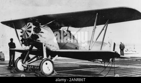 Boeing F2B-1 Jagdflugzeug an Bord der USS LANGLEY (CV-1), 1928. Dieses Foto zeigt die Verhaftung Gang im Einsatz. Zusätzlich zu den üblichen Schwanz Haken, das Flugzeug befördert eine "Kamm" Anordnung der geformten Verankerungshaken auf seinem Fahrwerk Vorderachse. Den engagierten eine Reihe von vorn und hinten die Kabel auf der Flight Deck des Luftfahrtunternehmens, das verhindert, dass der Flieger aus veering auf beiden Seiten. Die vordere und hintere Kabel können auf der Plattform unter dem Flugzeug gesehen werden. Wenn im Einsatz hatten, wurden sie das Deck von hölzernen' Geige Blocks' angehoben. Stockfoto