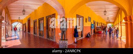 Dolores Hidalgo, Guanajuato, Mexiko - 25. November 2019: Menschen laufen durch eine Statue von Benito Juarez, die sich durch das Museum Del Bicentenario Stockfoto