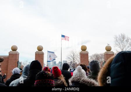 Krähe versammelten sich hinter dem Tor auf Liberty Island in New York City vor einer amerikanischen Flagge - New York City, NY, USA Stockfoto