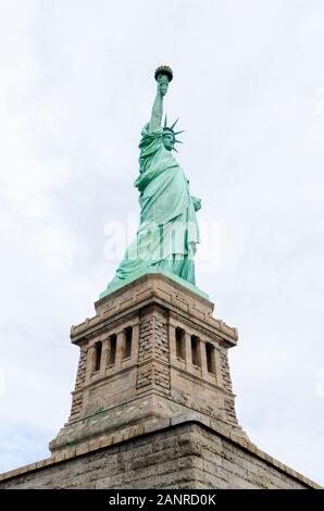 Seitenansicht Nahaufnahme der Freiheitsstatue auf Liberty Island in New York City mit bewölktem Himmel Stockfoto