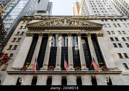 New York Stock Exchange Building im Winter mit einem Weihnachtsbaum und amerikanischen Flaggen in der Wall Street in Manhattan, New York, NY Stockfoto