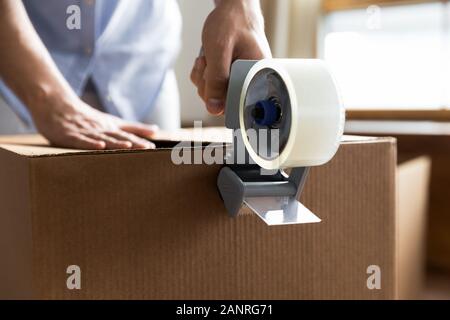 Nahaufnahme von Mann pack Boxen Abdichtung mit klebeband scotch Stockfoto