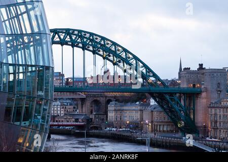 Ein Abendblick vorbei am Sage in Richtung Tyne Bridge und Newcastle upon Tyne, England. Die Brücke überspannt den Fluss Tyne. Stockfoto