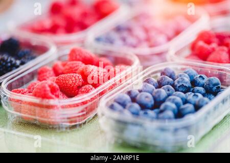 Kunststoffkästen mit Himbeeren, Heidelbeeren, Brombeeren auf Zähler der Markt store Stockfoto