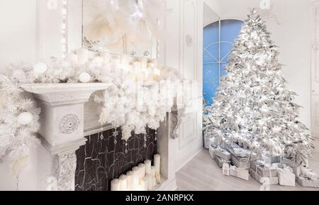 Innenraum Weihnachten Hintergrund mit illuminationen Baum, Kamin und Geschenke in Silber-weißes Licht Stockfoto