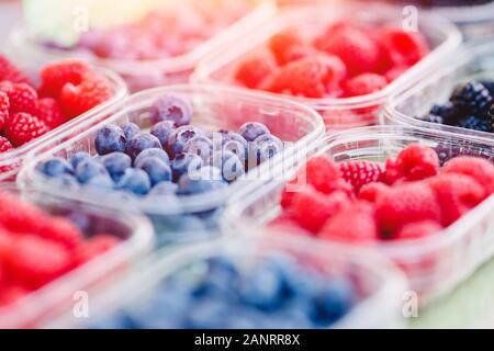 Kunststoffkästen mit Himbeeren, Heidelbeeren, Brombeeren auf Zähler der Markt store Stockfoto