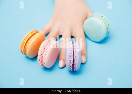 Schönheit hand Mädchen mit trendigen Maniküre unter Farbe makronen. Konzept haut Nagelpflege, Ansicht von oben Stockfoto