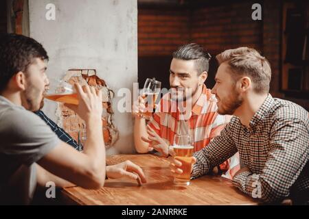 Handwerk Bier trinken aus Gläsern in einen Pub, eine Gruppe von männlichen Freunden. Konzept am Abend nach der Arbeit treffen Freundschaft Stockfoto