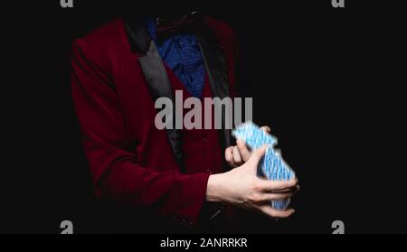 Fokus mit Spielkarten in den Händen des Magiers, schwarzer Hintergrund close-up Stockfoto