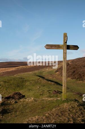 Wegweiser aus Holz an der Kreuzung auf Moorgebiet über Lastingham, North Yorkshire (Porträt) Stockfoto