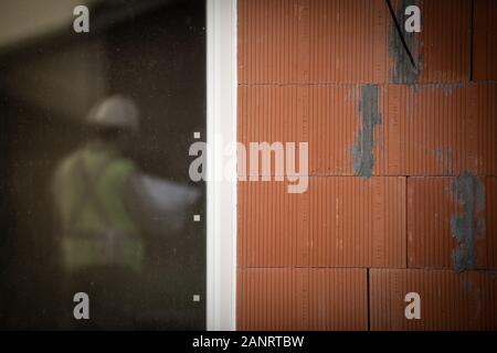 Professioneller Ingenieur Architekt Arbeiter mit Schutzhelm an Haus Baustelle Hintergrund Stockfoto