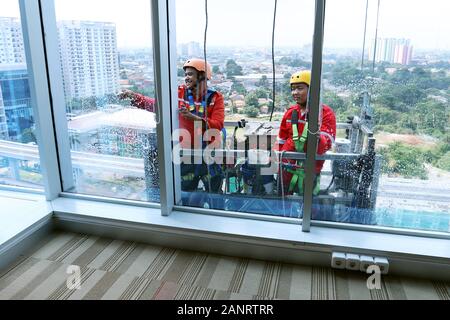 Zwei Arbeiter, die Fenster reinigen, werden im Hochhaus im Geschäftsviertel in Jakarta Indonesia eingesetzt. Stockfoto