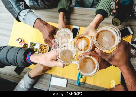 Eine Gruppe von Freunden, die eine Bierbrille im englischen Pub-Restaurant genießen - Junge Leute jubeln in der Vintage-Bar - Freundschaft, Happy Hour und Party-Konzept - Stockfoto