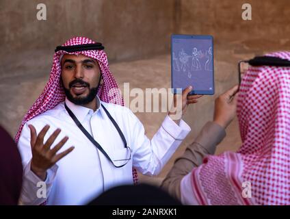 Saudi Guide mit Touristen in Madain Saleh, Al Madinah Province, Alula, Saudi-Arabien Stockfoto