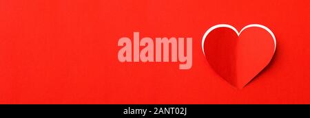 Valentines Tag Hintergrund. Ein rotes Blatt Papier mit ein ausgeschnittenes Herz. Weißer Hintergrund. Stockfoto