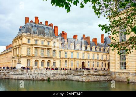 Chateau de Fontainebleau (Palast von Fontainebleau) mit Touristen im Cour de la Fontaine und im Gros Pavilion (großer Pavillon). Frankreich. Stockfoto