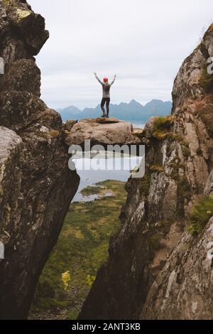 Tapfere Frau Reisende steht auf einem Hängestein zwischen Felsen Abenteuer Urlaub gesunde Lebensweise Wandern Outdoor-Erfolgsbilanz Konzept Stockfoto