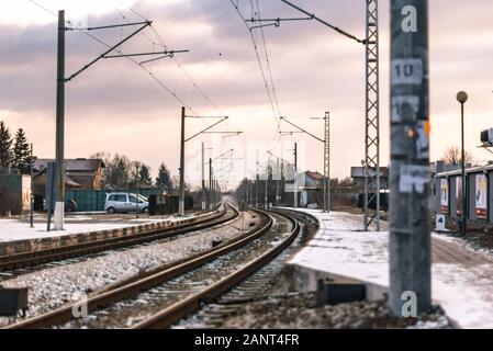 Wunderschöner Sonnenuntergang vom Bahnsteig durch die Stadtwolken im Winter Industrietransporte Stockfoto