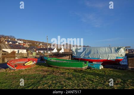 Kleine hölzerne Fischerboote gelagert werden, bis sie am Kai und auf dem Dorfplatz für den Winter in der Fischerei der Gemeinschaft der Johnshaven, Stockfoto