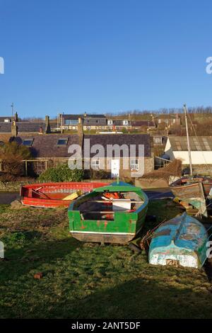 Hölzerne Fischerboote im Winter auf dem Dorfplatz neben dem Hafen im Küstenort Johnshaven. Stockfoto