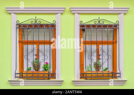 Blumenfenster mit Fenstergitter an einer bunten Straße in Visegrád Stockfoto