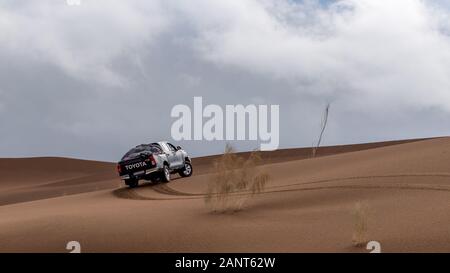 toyota hulux revo klettert eine Sanddüne, die Sand in einer Dasht e lut- oder sahara-Wüste umspritzt Stockfoto