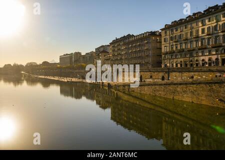 Hintergrundbeleuchtung der Murazzi von Po River Bank mit Menschen zu Fuß an einem sonnigen Wintertag, Turin, Piemont, Italien Stockfoto