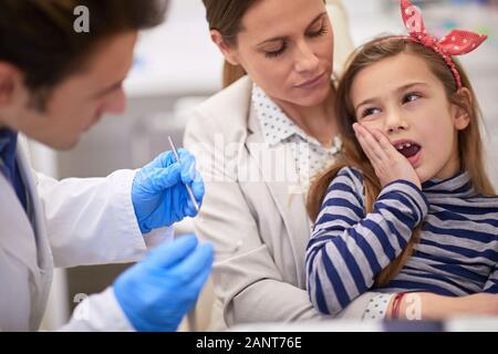Kleinkind Mädchen weigern, mit einem Zahnarzt unabhängig von ihrer Mutter Unterstützung zusammenzuarbeiten Stockfoto