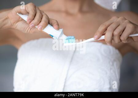 Nahaufnahme, Frau, Handtuch, aufgewickelt auf Zahnpasta Zahnbürste Stockfoto