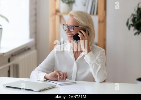 Im Alter von Geschäftsfrau, Reden auf dem Smartphone genießen Gespräch mit Client Stockfoto