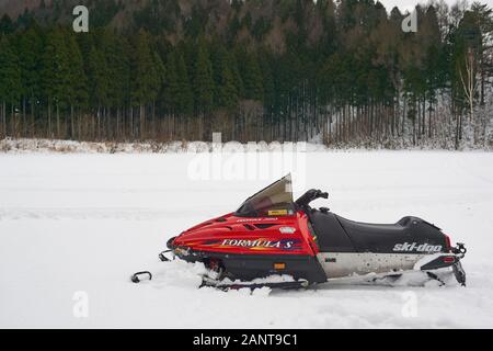 Formel S Skidoo Schneemobile (Schneemaschine, Motorschlitten, Motorschlitten, Skimobile, Motorroller, Schlitten) sitzt auf einem weißen Feld von Neuschnee. Stockfoto