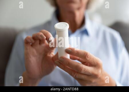 Nahaufnahme der älteren Frau mit weißem Kunststoff Flasche mit Pillen Stockfoto