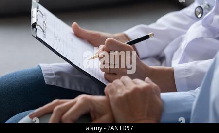 Close up Arzt ausfüllen ältere Patienten checkup Form, Dokumente Stockfoto