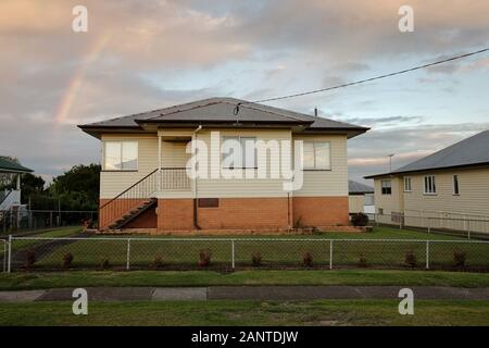 Hügelhaus mit Regenbogen am Himmel. Architektonische Untersuchung in den Brisbane-Vorstädten Carina, Camp Hill, Seven Hills, Cannon Hill, ihre Topografie. Stockfoto