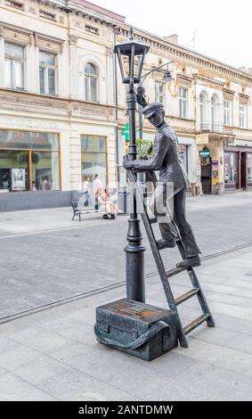 LODZ, Polen - 28. JULI 2016: anzünder Denkmal, das auf einer Leiter steht und die Glühbirne in der Lampe auf Pietrkovskoy Straße in Lodz ändern. Polen Stockfoto