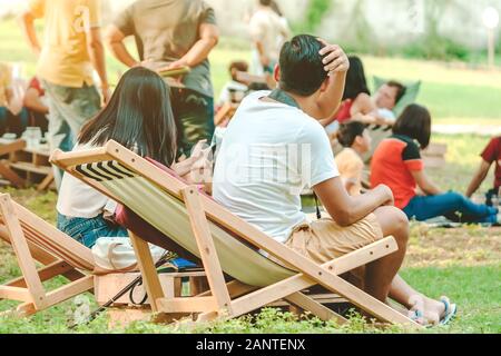 Glück Paar auf einem Sommerurlaub sitzen auf Stühlen im öffentlichen Park zu entspannen. Stockfoto