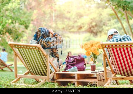 Glück Paar auf einem Sommerurlaub sitzen auf Stühlen im öffentlichen Park zu entspannen. Stockfoto