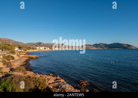 Strand und Bucht von Isla Plana, Murcia, Costa Calida, Spanien, EU. Blick in Richtung Cartagena. Blaues Wasser des Mittelmeers und blauer Himmel Stockfoto