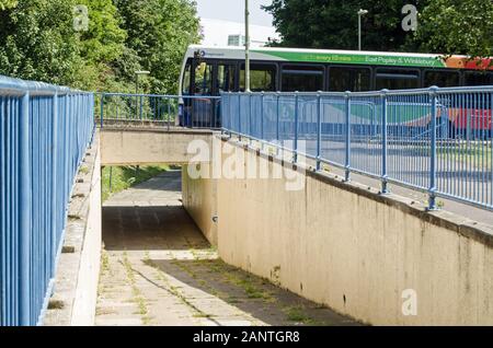 Basingstoke, Großbritannien - 23 Juli, 2019: Fußgänger Fußweg vorbei unter einer Hauptstraße mit einem Bus reisen Overhead. Sonnigen Sommertag in der Winklebu Stockfoto