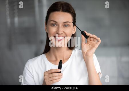 Kopf geschossen Portrait glücklich schöne Frau mit schwarzen mascara Bürste Stockfoto