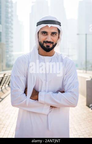 Mitte - östliche junge Erwachsene tragen kandora Walking im Freien in Dubai - Arabische Emirate Mann die traditionelle Kleidung Stockfoto