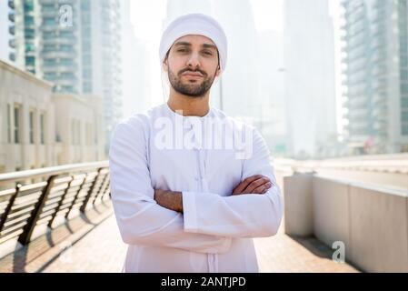 Mitte - östliche junge Erwachsene tragen kandora Walking im Freien in Dubai - Arabische Emirate Mann die traditionelle Kleidung Stockfoto
